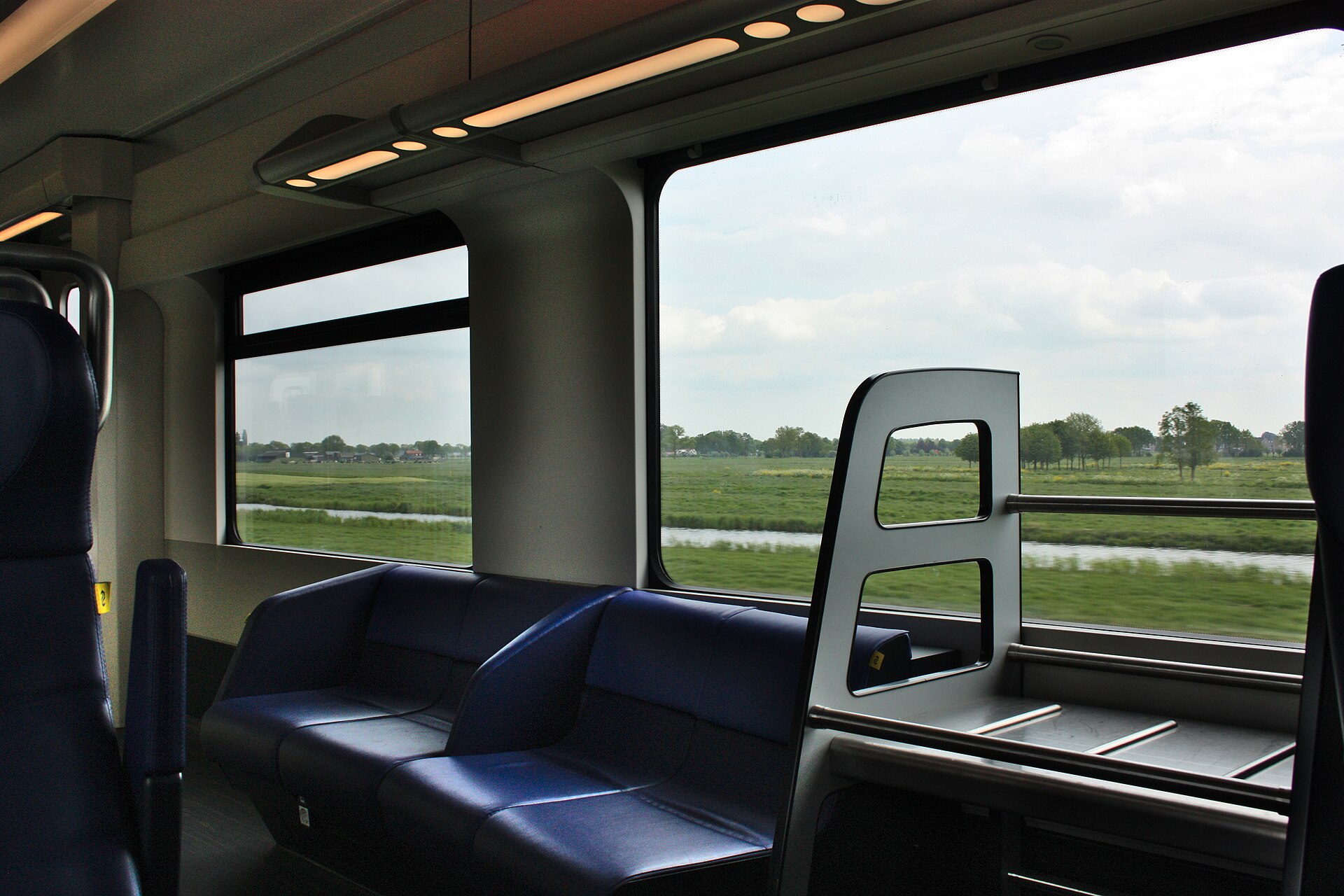 Uitzicht vanuit een rijdende NS-trein over het Nederlandse polderlandschap